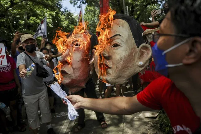 Activists burn masks of Ferdinand “Bongbong” Marcos Jr. and running mate Sara Duterte, daughter of the current president, during a rally at the Commission on Human Rights in Quezon City, metro Manila, Philippines on Wednesday. May 25, 2022. Marcos Jr. continues to lead in the official canvassing of votes. (Photo by Basilio Sepe/AP Photo)