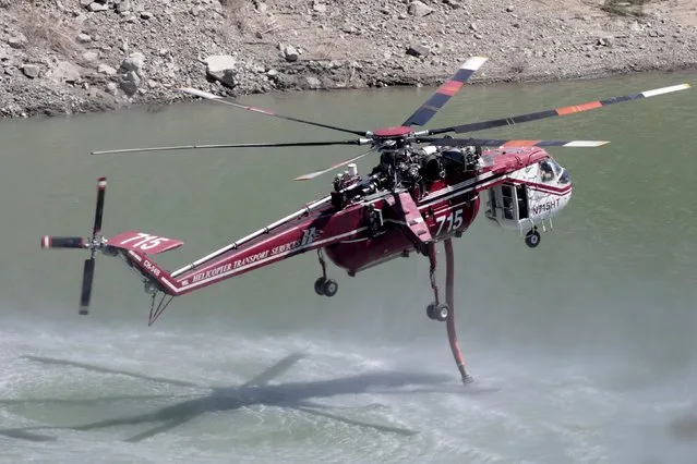 A firefighting helicopter fills up with water to drop on the so-called “Cabin Fire” in the Angeles National Forest near Los Angeles, California, August 15, 2015. (Photo by Jonathan Alcorn/Reuters)