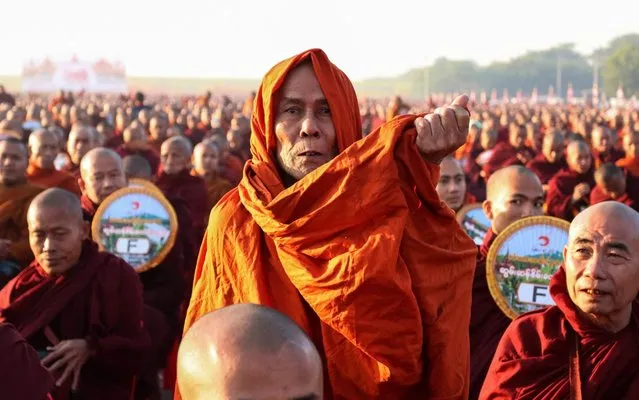 Monks line up for alms during the alms-giving ceremony to 30,000 monks organize by the region government of Mandalay affiliated with Dhammakaya Foundation at Chanmyathazi Airport in Mandalay on December 8, 2019. Thirty-thousand monks assembled in the early morning chill of Mandalay for a spectacular alms-giving event involving a controversial mega-temple under scrutiny across the border in Thailand. (Photo by Kyaw Zay Win/AFP Photo)