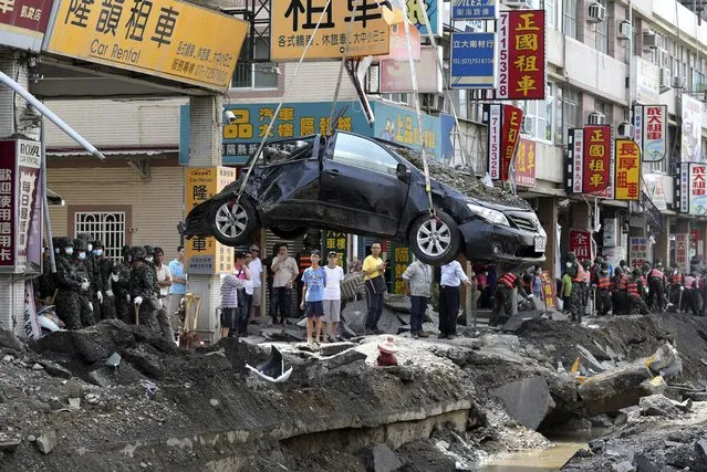 A damaged car is removed from the wreckage after an explosion in Kaohsiung, southern Taiwan, August 2, 2014. A series of explosions caused by a gas leak killed 25 people and injured 267 in Taiwan's second city on Friday, sending flames shooting 15 storeys into the air, setting ablaze entire blocks and reducing small shops to rubble. (Photo by Edward Lau/Reuters)