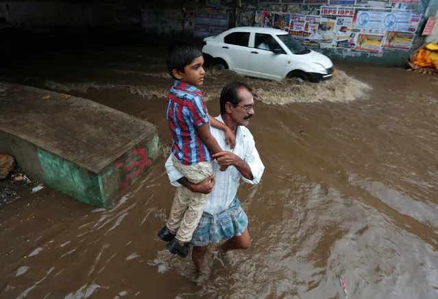 A man carries a child as he wades through a waterlogged subway after heavy rains in Chennai, India August 9, 2017. (Photo by P. Ravikumar/Reuters)