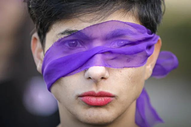 A woman wearing a purple band across her eyes takes part in a flashmob dubbed “The Rapist is You” to raise awareness to the high levels of violence and prejudice against women in Bucharest, Romania, Sunday, March 1, 2020. “A Rapist in Your Path” or “The Rapist Is You”, is originally a Chilean feminist performance piece protesting violence against women which was performed in Latin America, the United States, and Europe. (Photo by Vadim Ghirda/AP Photo)