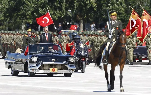 Turkey's President Tayyip Erdogan (in the car with a black suit), flanked by Chief of Staff General Hulusi Akar (standing behind Erdogan) and a commander (L), arrives at a parade marking the 93rd anniversary of Victory Day in Ankara, Turkey, August 30, 2015. (Photo by Umit Bektas/Reuters)