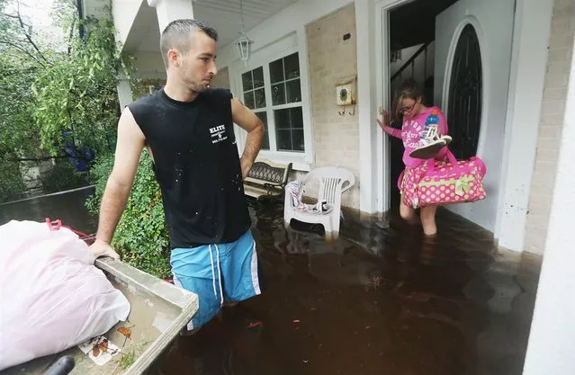 Brittany Trumbaturi departs her flooded home in Slidell, La., with Joshua Barbot, who came to rescue family members in a boat on Aug. 30. (Photo by Mario Tama)