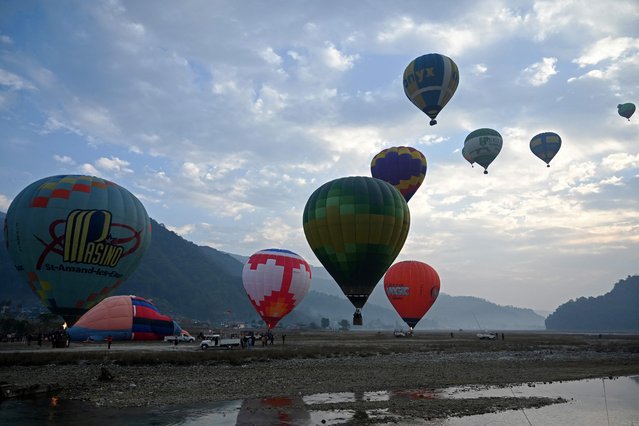 Hot air balloons rise in sky during the international festival at Pokhara in Nepal on December 25, 2024. (Photo by Prakash Mathema/AFP Photo)