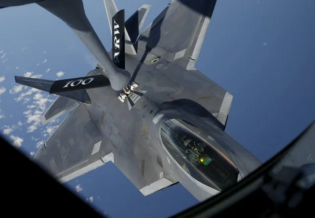 A F-22 Raptor fighter jet of the 95th Fighter Squadron from Tyndall, Florida is seen during refuelling by a KC-135 Stratotanker from the 100th Air Refueling Wing at the Royal Air Force Base in Mildenhall in Britain as they fly over the Baltic Sea towards Spangdahlem airbase, Germany September 4, 2015. (Photo by Wolfgang Rattay/Reuters)