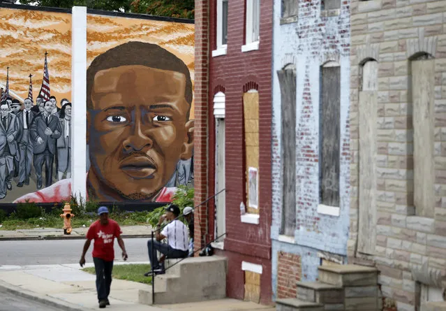 A mural depicting Freddie Gray is seen past blighted row homes in Baltimore, Thursday, June 23, 2016, at the intersection where Gray was arrested. (Photo by Patrick Semansky/AP Photo)
