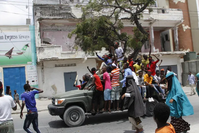 Protesters march near the scene of Saturday's massive truck bomb attack in Mogadishu, Somalia, Wednesday, October 18, 2017. Thousands of people took to the streets of Somalia's capital Wednesday in a show of defiance after the country's deadliest attack, as two people were arrested in connection with Saturday's massive truck bombing that killed more than 300. (Photo by Farah Abdi Warsameh/AP Photo)
