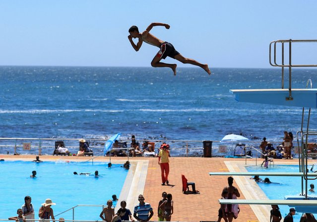 A person dives from a springboard during a hot summer day at Sea Point swimming pool in Cape Town, South Africa, on January 10, 2025. (Photo by Esa Alexander/Reuters)