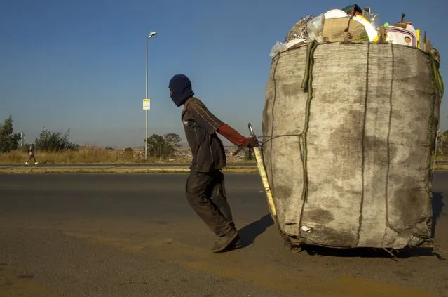 A man pulls a trolley filled with cardboard and plastic bottles for recycling through the streets at Phumlamqashi informal settlement near Johannesburg, South Africa, Wednesday, June 3, 2020. (Photo by Themba Hadebe/AP Photo)