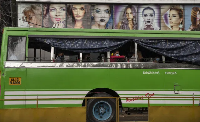 Passengers wearing face masks sit inside a bus as it halts before a beauty salon during the coronavirus pandemic in Kochi, Kerala state, India, Monday, June 1, 2020. More states opened up and crowds of commuters trickled on the roads in many cities as India's three-phase plan to lift the virus lockdown kick started Monday amidst an upward trend in new infections and fatalities due to COVID-19. (Photo by R.S. Iyer/AP Photo)