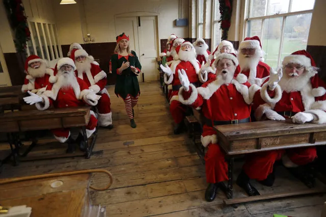 Performers dressed as Santa Claus take part in a posed classroom photocall for the media for the Ministry of Fun Santa School at the Ragged School Museum in east London, Thursday, November 16, 2017. The Ministry of Fun Santa School is Britain's only genuine training school for professional Santas, preparing them to help out in grottos, department stores, attractions and events over the Christmas period. (Photo by Matt Dunham/AP Photo)