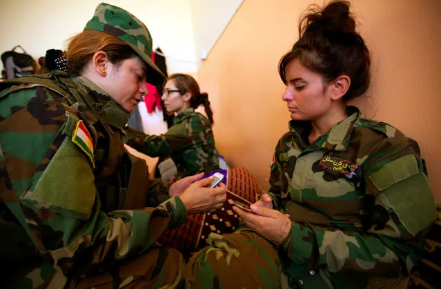 Yazidi females who have joined the Kurdish Peshmerga forces chat in Shingal, Iraq, August 24, 2016. (Photo by Ari Jalal/Reuters)