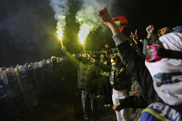 People shout slogans next to anti riot police officers during a protest after Istanbul's Mayor Ekrem Imamoglu was arrested and sent to prison, in Istanbul, Turkey, Monday, March 24, 2025. (Photo by Khalil Hamra/AP Photo)