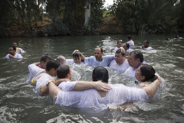 Christian pilgrims from Brazil are baptized in the water of the Jordan River during a ceremony at the Yardenit baptismal site near the northern Israeli city of Tiberias October 15, 2014. Yardenit is one of the sites along the Jordan River where it is believed Jesus was baptized. (Photo by Finbarr O'Reilly/Reuters)