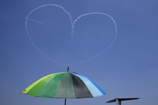 Indian Air Force's aerobatic team Suryakiran make a formation in the shape of a heart from a trail of smoke as they perform on the last day of the Aero India 2025, a biennial event, at Yelahanka air base in Bengaluru, India, Friday, February 14, 2025. (Photo by Aijaz Rahi/AP Photo)