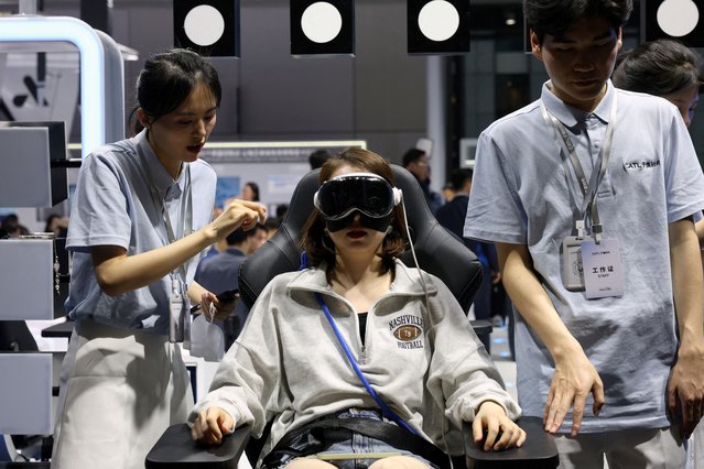 A woman wears a pair of virtual reality (VR) goggles at the CATL booth during a media day for the Auto Shanghai show in Shanghai, China on April 23, 2025. (Photo by Go Nakamura/Reuters)