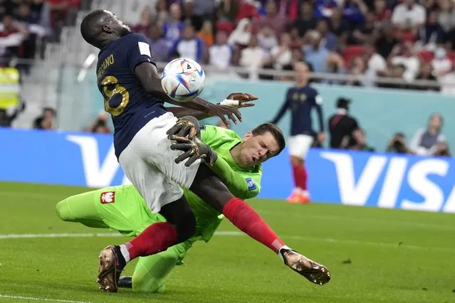 France's Dayot Upamecano, left, and Poland's goalkeeper Wojciech Szczesny, right, collide during the World Cup round of 16 soccer match between France and Poland, at the Al Thumama Stadium in Doha, Qatar, Sunday, December 4, 2022. (Photo by Natacha Pisarenko/AP Photo)