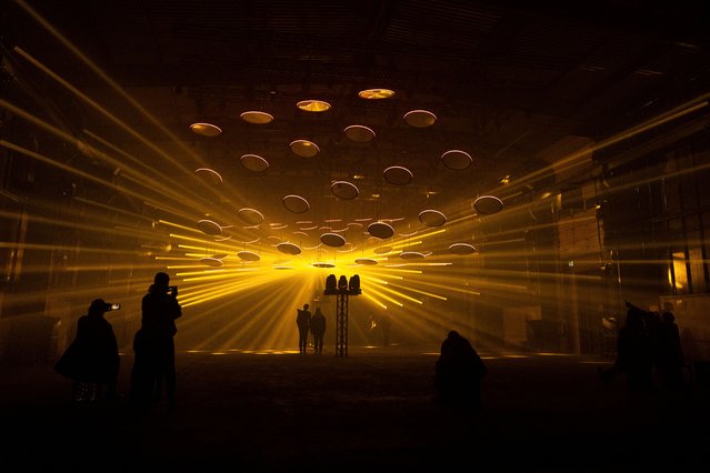 People watch the light, audio-visual kinetic art installation SKALAR at the DARK MATTER exhibition, presenting the works of light and media artist Christopher Bauder and Kangding Ray in Berlin, Germany on April 1, 2025. (Photo by Nadja Wohlleben/Reuters)