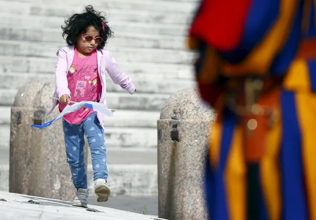 A child walks past a Swiss guard as Pope Francis leads the weekly audience in Saint Peter's Square at the Vatican September 16, 2015. (Photo by Tony Gentile/Reuters)