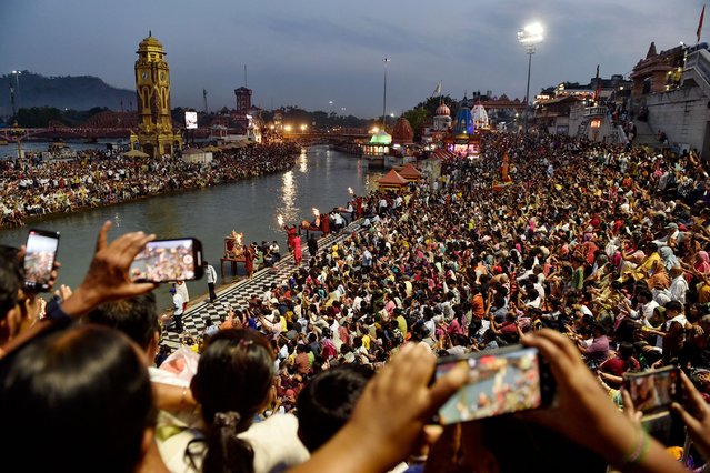 Hindu devotees attend aarti, a ritual that involves lit lamps to seek blessings, during evening prayers at the Har Ki Pauri ghat along the banks of river Ganges in Haridwar on April 26, 2025. (Photo by Shammi Mehra/AFP Photo)