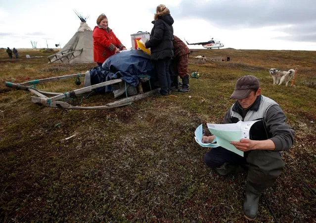 Herders fill out their ballots during early voting in the elections to the lower house of parliament in remote areas at a reindeer camping ground on the banks of the Barents Sea, north of Naryan-Mar in Nenets region, Russia September 12, 2016. (Photo by Sergei Karpukhin/Reuters)