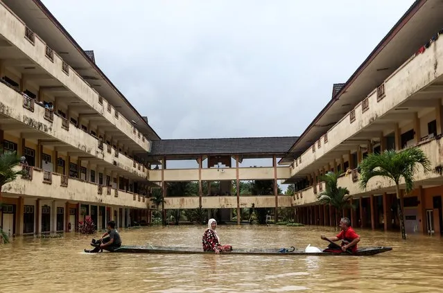 Residents are rescued by a boat from the flood relief centre as the flood water rise and partially submerged the building at Dungun, Terengganu, Malaysia on December 21, 2022. More than 70000 were forced into relief centres, with numbers rising in Kelantan, Terengganu and Pahang, according to local media. (Photo by Reuters/Stringer)