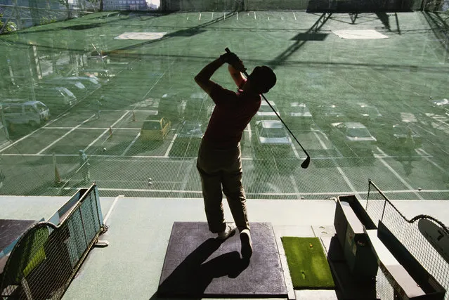 Players practice their golf swings at a city golf driving range on 15th October 1990 in the Ginza district in Tokyo, Japan. (Photo by Pascal Rondeau/Getty Images)