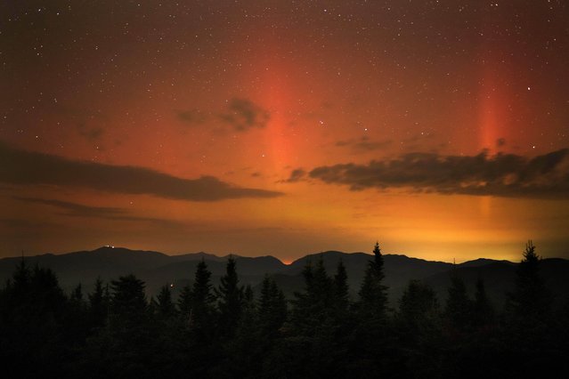 Flares of northern lights color the sky over the White Mountains just after midnight, Friday, September 13, 2024, as viewed from a mountaintop in Chatham, N.H. Lights on the summit of Mount Washington can be seen on the ridgeline at left. (Photo by Robert F. Bukaty/AP Photo)