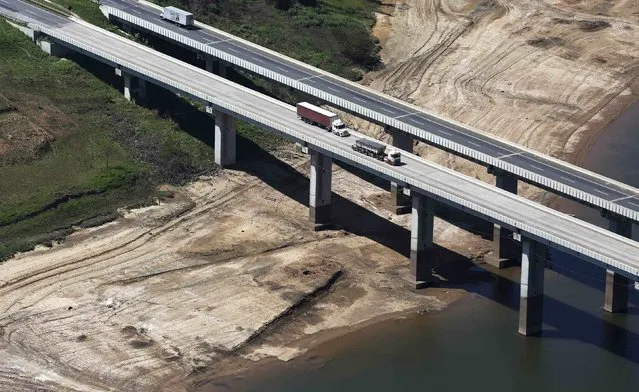 Trucks drive along a bridge over the dry lakebed of the Atibainha dam, part of the Cantareira reservoir, during a drought in Nazare Paulista, Sao Paulo state November 18, 2014. (Photo by Nacho Doce/Reuters)