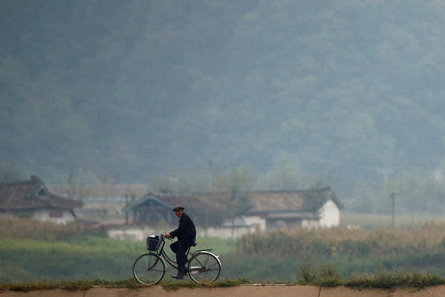 A man cycles along the bank of the Yalu River, outside the North Korean town of Sinuiju, opposite Dandong in China's Liaoning province, September 10, 2016. (Photo by Thomas Peter/Reuters)