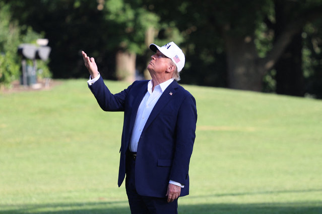 US President Donald Trump stops to gesture at the US flag as he walks on the South Lawn from Marine One to the White House in Washington, DC on July 6, 2025, after spending the weekend at his residence in Bedminster, New Jersey. (Photo by Alex Wroblewski/AFP Photo)