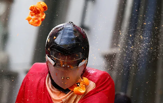 A member of a team is hit by oranges during an annual carnival battle in the northern Italian town of Ivrea, Italy on February 11, 2018. (Photo by Alessandro Bianchi/Reuters)