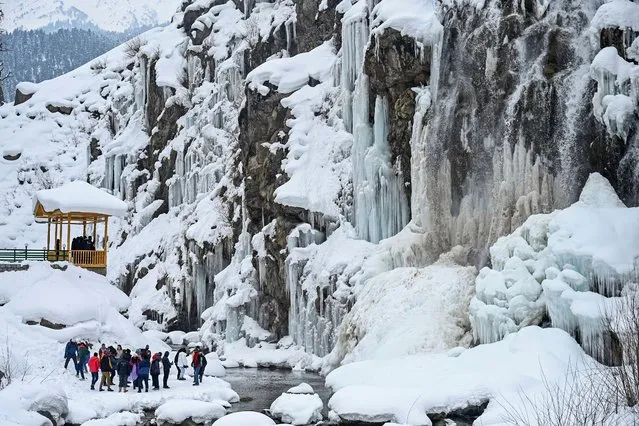 Tourists visit a frozen waterfall in the Drang area of Tangmarh on February 2, 2023. (Photo by Tauseef Mustafa/AFP Phoot)