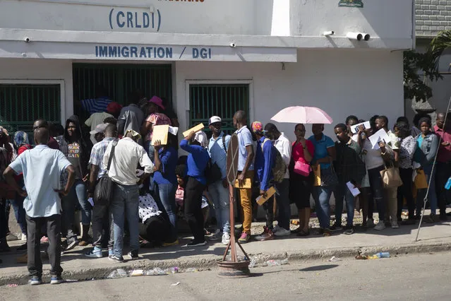 Haitians line up outside an immigration office as they wait their turns to apply for a passport, in Port-au-Prince, Haiti, Tuesday, January 10, 2023. President Joe Biden announced a massive expansion of humanitarian parole on Jan. 5 for Cubans, Haitians, Venezuelans and Nicaraguans that is reserved for those who apply online, pay airfare and have a financial sponsor for two years. (Photo by Joseph Odelyn/AP Photo)