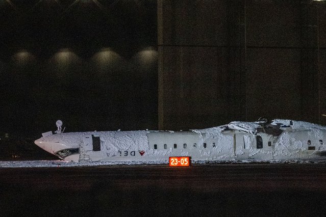 A Delta Air Lines passenger plane is shown flipped upside down at Toronto Pearson International Airport in Mississauga, Canada, 17 February 2025. According to a preliminary statement from the United States Federal Aviation Administration (FAA), the flight Endeavor Air was operating crashed while landing at the airport, and all 80 people on board were evacuated. (Photo by Eduardo Lima/EPA)