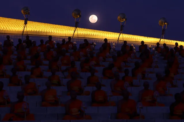 The full moon is seen as buddhist monks attend a ceremony on Makha Bucha Day at Wat Phra Dhammakaya in Pathum Thani, Thailand, March 1, 2018. (Photo by Athit Perawongmetha/Reuters)