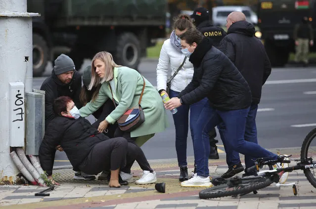 People help a woman after she collided with a police during an opposition rally to protest the official presidential election results in Minsk, Belarus, Sunday, November 1, 2020. (Photo by AP Photo/Stringer)