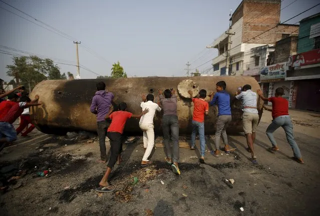 Protesters try to move a diesel tank confiscated by the protester to block a highway during a general strike called by the Madhesi protesters protesting against the new constitution in Birgunj, Nepal November 4, 2015. Nepal has faced an acute fuel crisis for more than a month since protesters in the lowland south, angered that a new constitution fails to reflect their interests, prevented supply trucks from entering from India. (Photo by Navesh Chitrakar/Reuters)