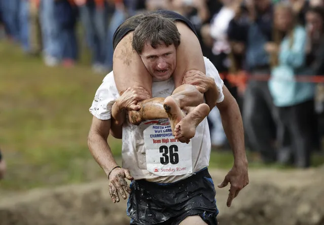 Greg Goodhue carries Wendy Hallenbeck, both of Sydney, Maine, during the North American Wife Carrying Championship, Saturday, October 8, 2016, at the Sunday River Ski Resort in Newry, Maine. (Photo by Robert F. Bukaty/AP Photo)