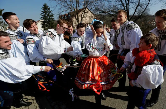 Men wearing traditional costumes whip a girl with willow sticks during Easter celebrations in Vlcnov, Czech Republic, April 2, 2018. (Photo by David W. Cerny/Reuters)
