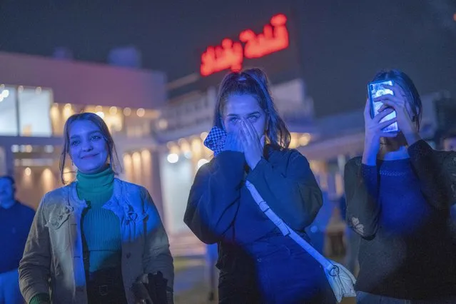 Youths gather along the Tigris River for a concert by rap artist OG Khalifa in Baghdad, Iraq, Saturday February 25, 2023. One of the songs he performs mocks “sheikhs”, those who wield power in the new Iraq through wealth or political connections. (Photo by Jerome Delay/AP Photo)