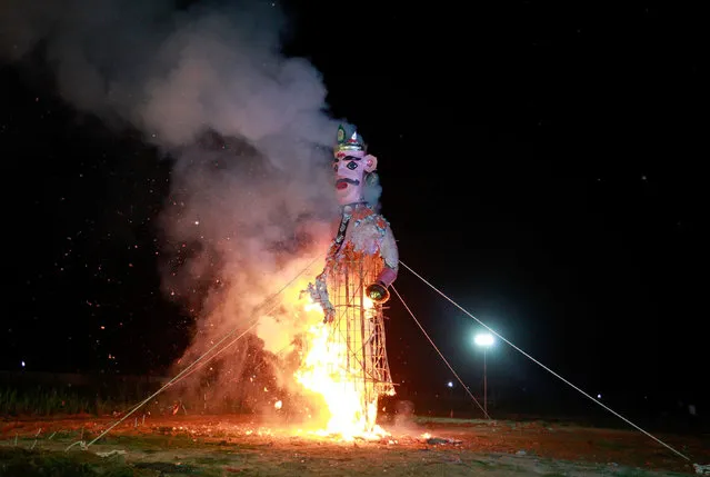 Fireworks explode as an effigy of Kumbhkarana, brother of demon king Ravana, burns during Vijaya Dashmi or Dussehra festival celebrations in Ahmedabad, India, October 11, 2016. (Photo by Amit Dave/Reuters)