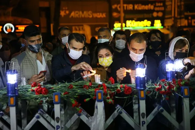 People place flowers and light candles during a commemorative ceremony held for earthquake victims, in Izmir, Turkey on November 5, 2020. (Photo by Halil Fidan/Anadolu Agency via Getty Images)