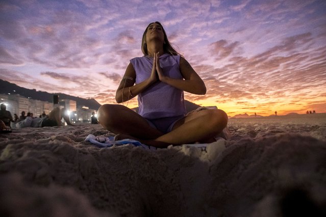 A woman sits in lotus prayer pose during the “Yoga at the Sunrise” event on Copacabana beach, in Rio de Janeiro, Saturday, June 22, 2024. The activity celebrates International Yoga Day proclaimed by the United Nations as June 21. (Photo by Bruna Prado/AP Photo)