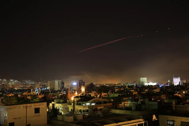 Explosions lit up the skies with anti-aircraft fire, over Damascus, the Syrian capital, as the U.S. launches an attack on Syria targeting different parts of the Syrian capital Damascus, Syria, early Saturday, April 14, 2018. (Photo by Hassan Ammar/AP Photo)