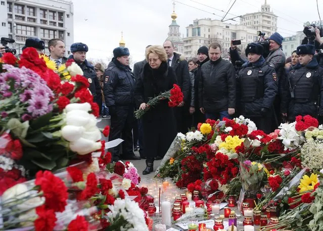 Federation Council Speaker Valentina Matviyenko  (C) puts flowers near the French embassy to commemorate victims of the Paris attacks, in Moscow, Russia, November 14, 2015. (Photo by Maxim Zmeyev/Reuters)