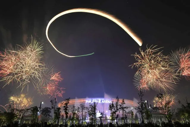 Spectators watch as fireworks light the sky during New Year celebrations outside the Philippine Arena in Bocaue town, Bulacan province, north of Manila January 1, 2015. (Photo by Ezra Acayan/Reuters)