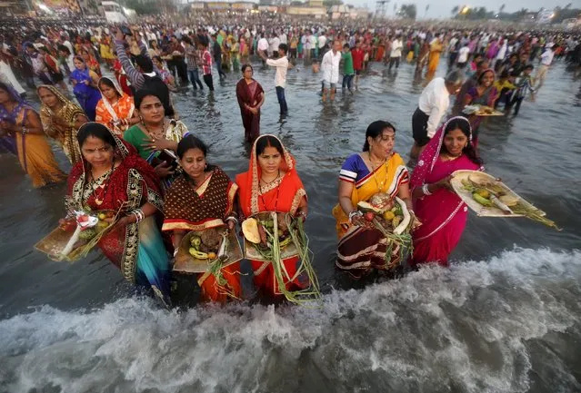 Hindu women worship the Sun god Surya while standing in the waters of the Arabian Sea during the Hindu religious festival of Chatt Puja in Mumbai, India, November 17, 2015. (Photo by Shailesh Andrade/Reuters)