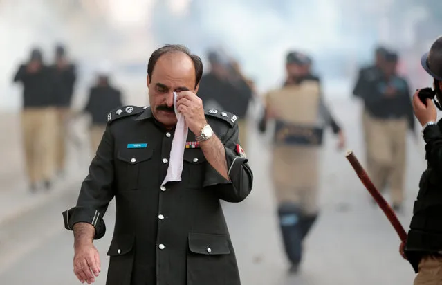 Police officer recovers from the blowback of tear gas during clashes in Rawalpindi, Pakistan October 28,  2016. (Photo by Caren Firouz/Reuters)